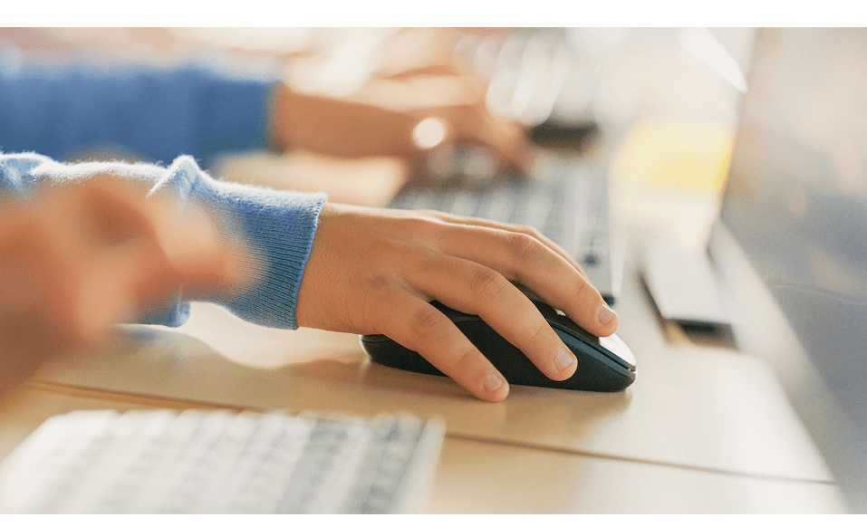 Hand using a computer mouse on a desk